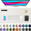 A large PU leather desk mat is shown with a laptop, keyboard, mouse, and a coffee cup on a light surface.
