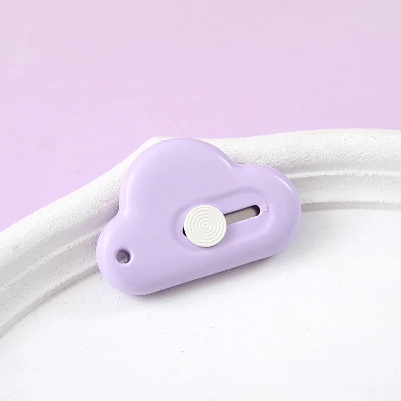 A small, light purple portable utility knife with a round button and blade visible on a white background.