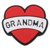 A heart-shaped enamel pin featuring the word GRANDMA in white text on a red background.