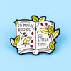 An enamel lapel pin shaped like an open book with leaves and text reading So many books so little time