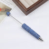 A silver pen with a blue rhinestone tip and a matching blue beaded accessory is displayed on a white surface.