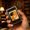 A hand holds a vintage stainless steel card and cash case displaying an orange silhouette of a woman's profile on a yellow ba