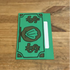A green card holder with a design featuring a shell and dollar sign symbol on a wooden surface.