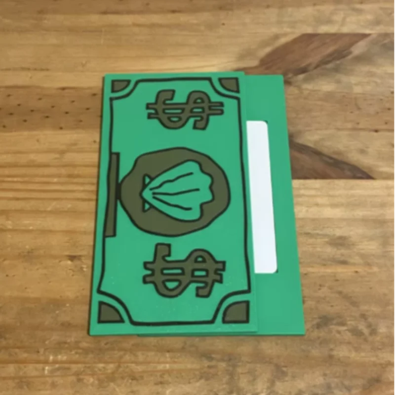 A green card holder with a design featuring a shell and dollar sign symbol on a wooden surface.