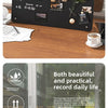 A black magnetic planning board displays a menu, schedule, and various notes on a wooden table.