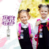Two girls wearing black dresses and pink backpacks holding retractable badge reels with glitter acrylic designs