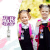 Two young girls smiling while holding retractable badge reels with glitter acrylic designs.