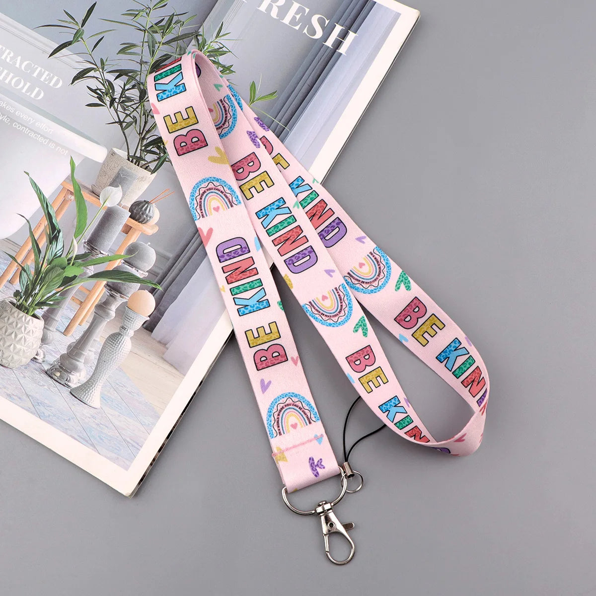 Pink lanyard with rainbow text Be Kind for an autism awareness ID badge holder