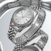 A close-up shot of a polished stainless steel watch with a silver dial and bracelet on a reflective surface.