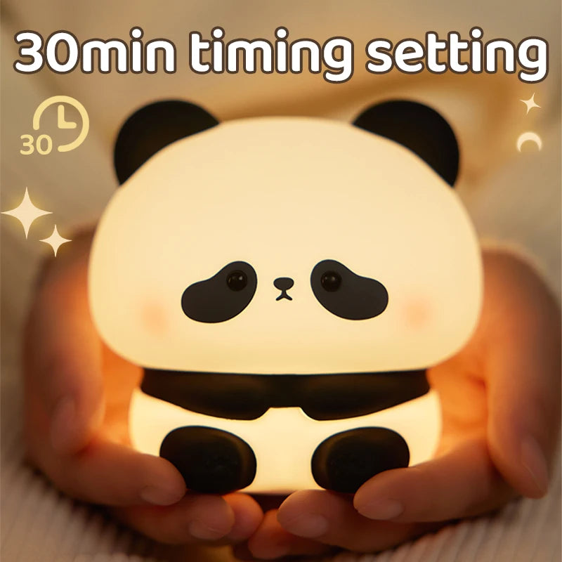 A hand is holding a cute panda silicone night light with a warm glow.