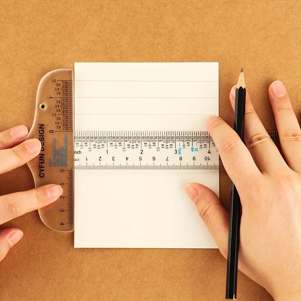 Hands hold a pencil and an acrylic ruler against a piece of paper on brown craft paper.