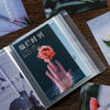 A photo storage booklet featuring a close-up of a hand holding a rose, with Japanese text on the cover.