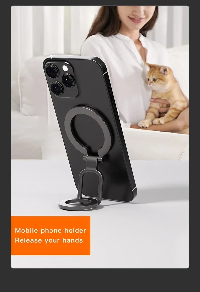 Black double-sided magnetic phone holder with a metal kickstand on a white table.