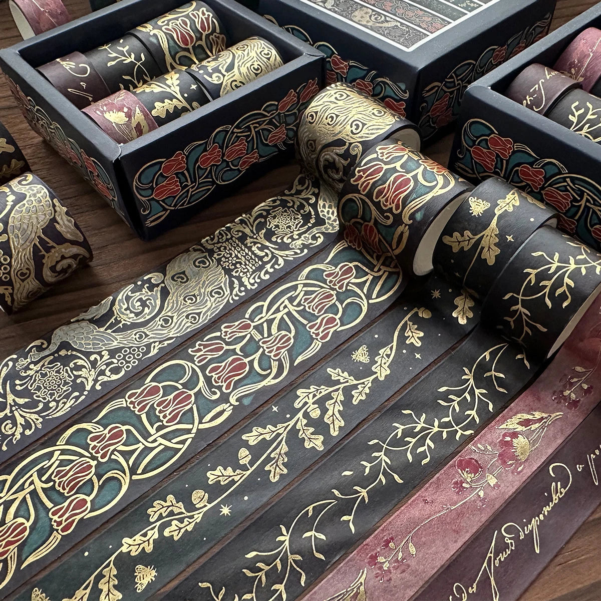 A set of metallic gold washi tape rolls in various shades and patterns displayed in a wooden box.