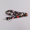 A black lanyard featuring colorful, stylized eye designs on a heart shape.