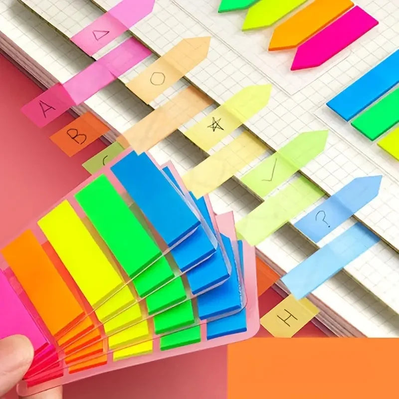 A hand holds a stack of fluorescent PET sticky notes with index tabs in various bright colors.