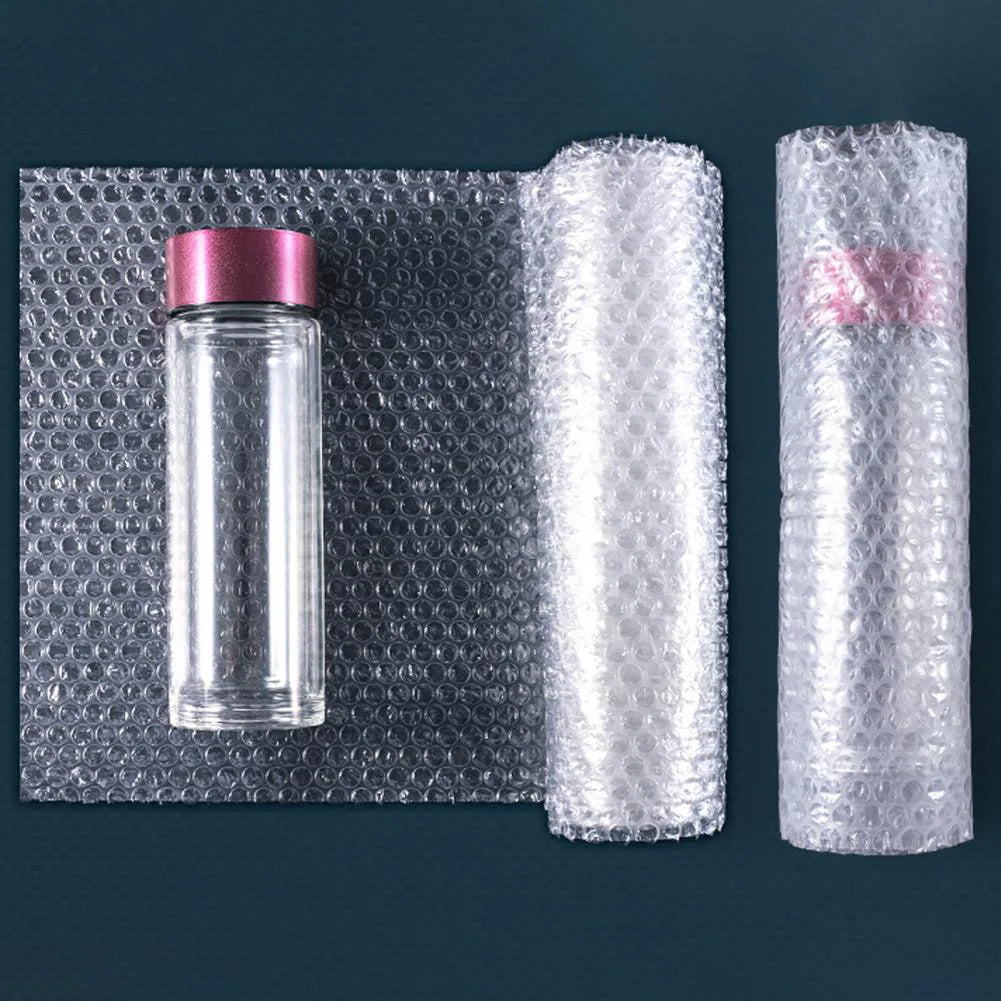 A clear glass bottle with a pink cap is shown next to two rolls of thick bubble wrap packaging.