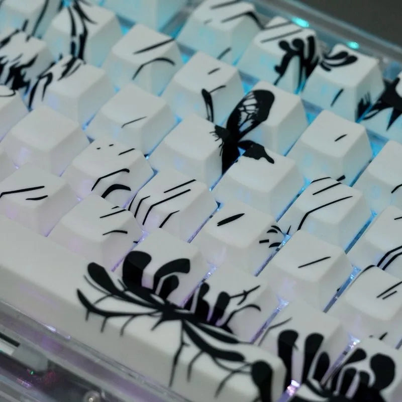 A close-up view of a custom keycap set featuring black and white anime designs on white PBT cherry profile keycaps.