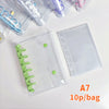 A clear double-button binder for stickers and journaling with green and purple accessories.