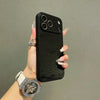 A hand holds a black phone case with a frosted velvet texture and shockproof protection against a gray background.