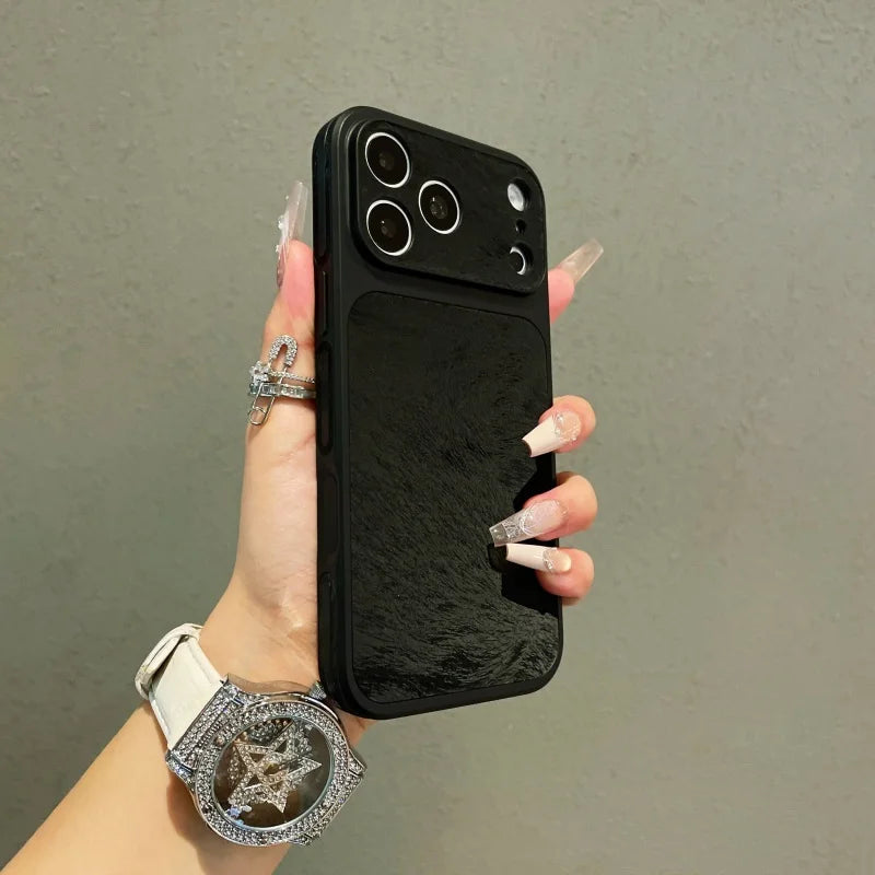 A hand holds a black phone case with a frosted velvet texture and shockproof protection against a gray background.