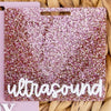A square acrylic badge holder with a glittery magenta background and the word ultrasound written in white script.