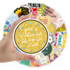 A hand holds a circular arrangement of inspirational Bible verse stickers featuring verses like God is Within Her She Will No