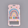 A pink ID badge holder featuring a rainbow design and the text BE KIND
