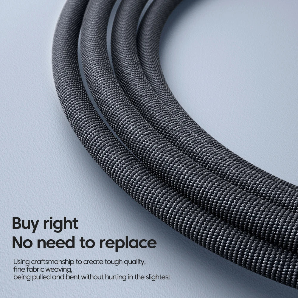 Close-up of a black braided nylon charging cable coiled and bent against a light gray background.