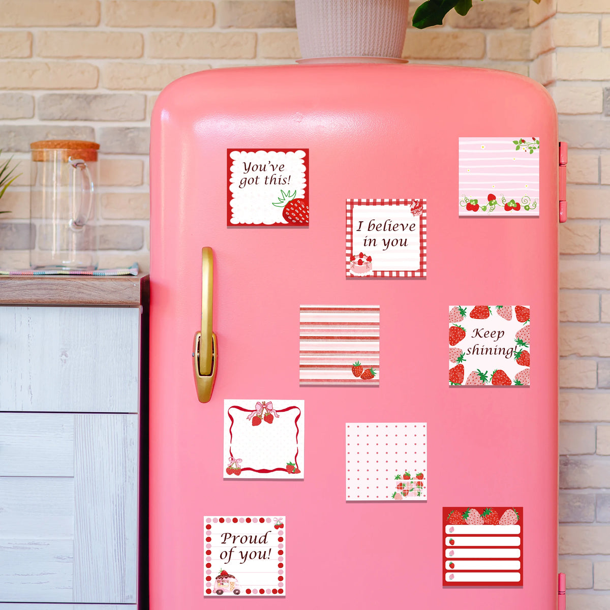 A pink thermos bottle decorated with various strawberry-themed self-stick memo notes.