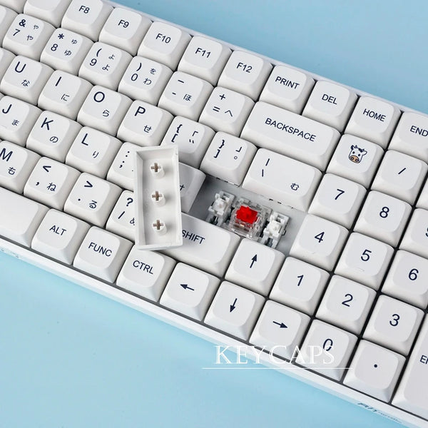 A close-up view of white PBT keycaps for a mechanical keyboard, showing various alphanumeric and function keys.