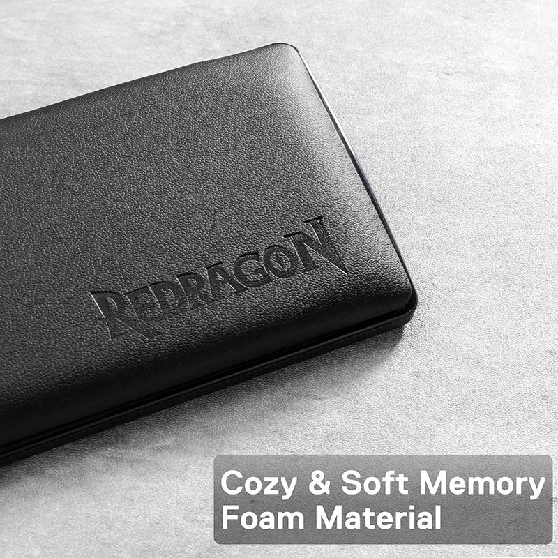 A black Redragon memory foam keyboard wrist rest lying on a light gray surface.
