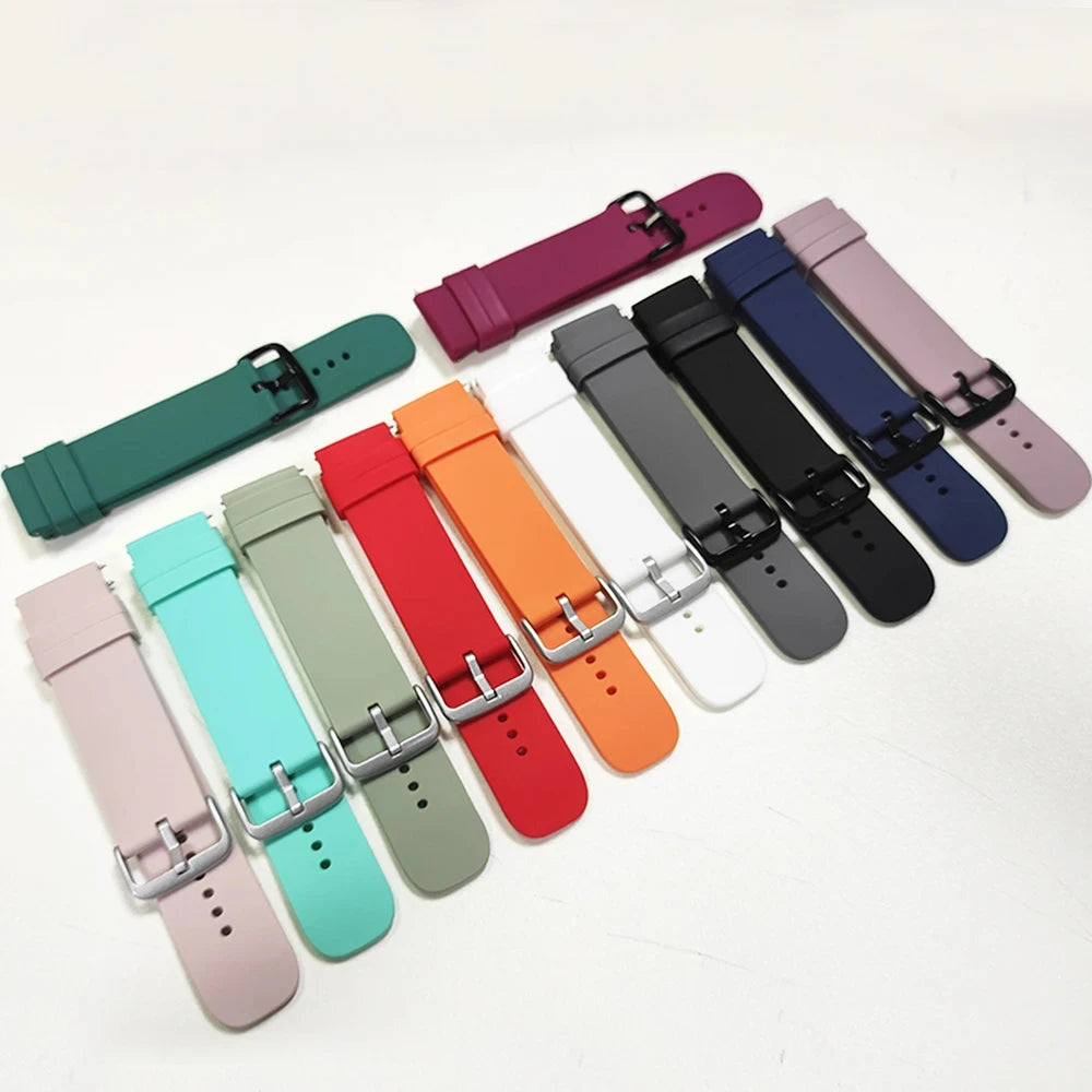 A collection of silicone watch bands in various colors including purple, pink, blue, black, and orange laid out on a white su
