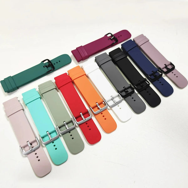 A collection of silicone watch bands in various colors including purple, pink, blue, black, and orange laid out on a white su