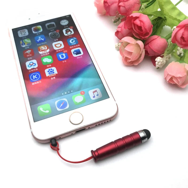 A pink tablet displaying an app interface with a red stylus connected by a wire.