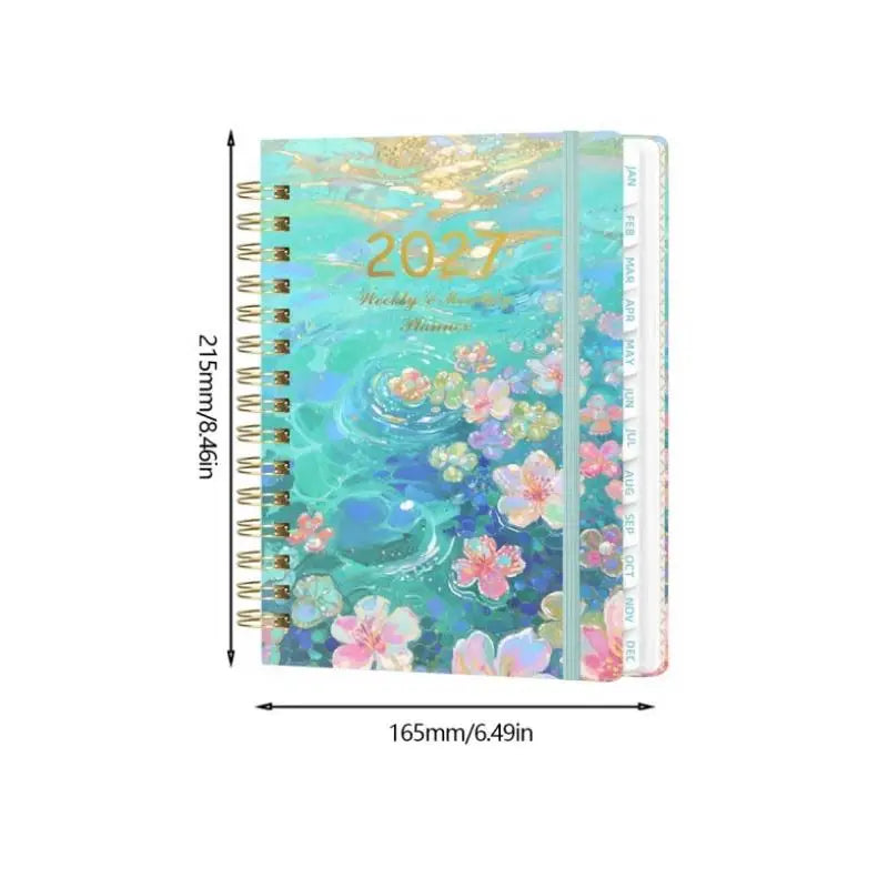 A spiral bound planner featuring a teal cover with gold accents and monthly tabs.
