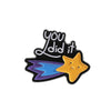 A black enamel pin featuring the text You did it and a yellow star design.