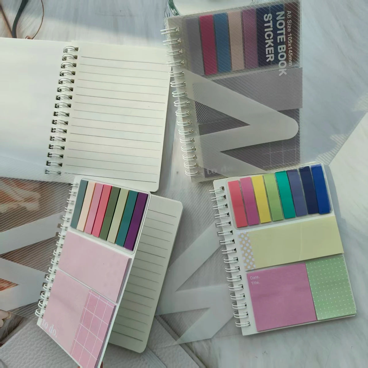 A collection of colorful sticky note notebooks and sheets with various pastel and muted tones.