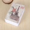 A small notebook or dictionary with a cover featuring the Eiffel Tower and floral designs.