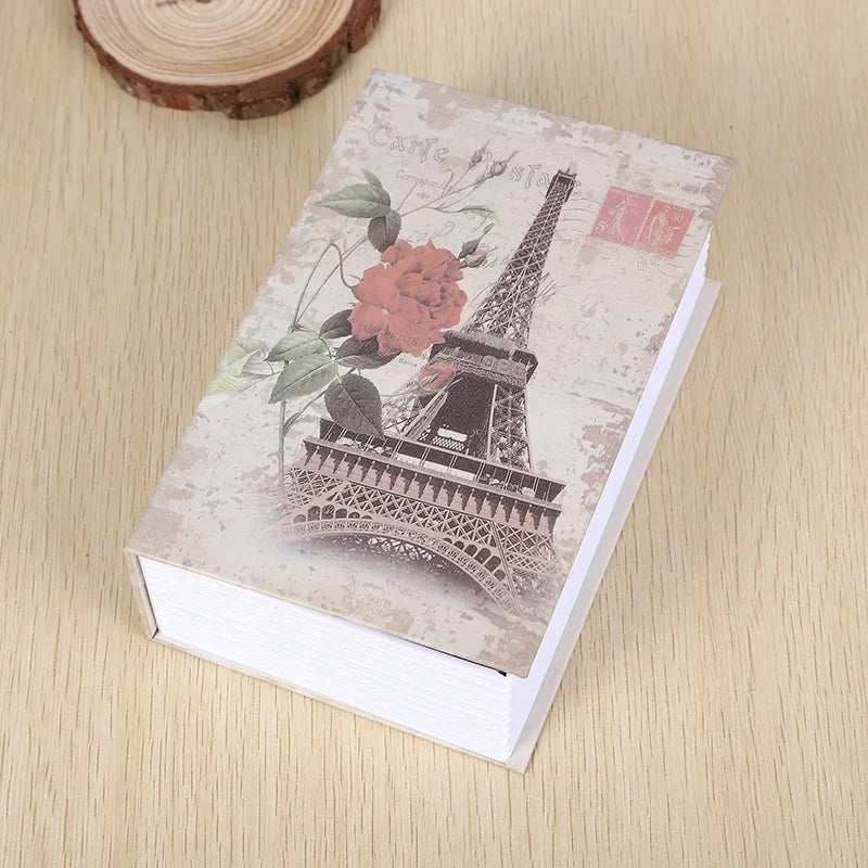 A small notebook or dictionary with a cover featuring the Eiffel Tower and floral designs.
