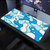 A blue and white wave pattern mouse pad placed on a dark desk next to a computer monitor.