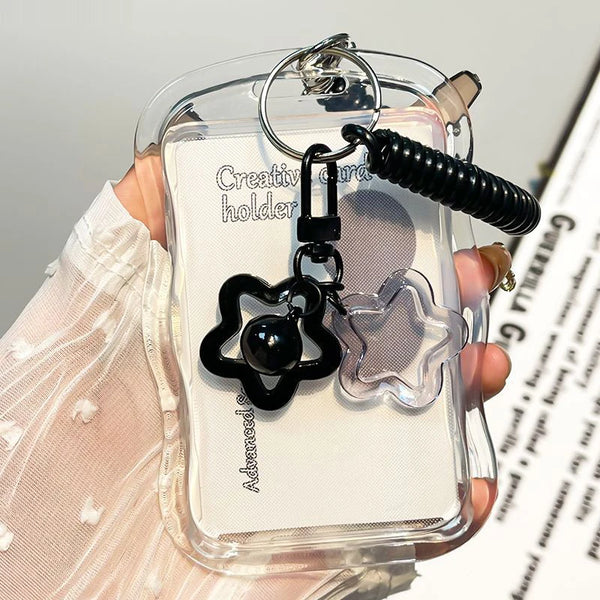 A clear card holder with a keychain featuring a black paw print and a silver star charm.