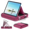 A pink foldable tablet pillow stand with a screen displaying a tropical scene and a stylus holder.