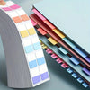A close-up view of colorful durable writable index tags arranged in a vertical strip on a sheet of paper.