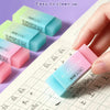 A hand holds a light blue pencil with a pink eraser and several translucent plastic refills on a grid paper background.
