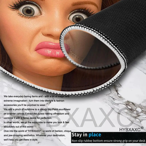 A close-up of a doll face with large eyes and pink lips, showing a black mouse pad rolled open.