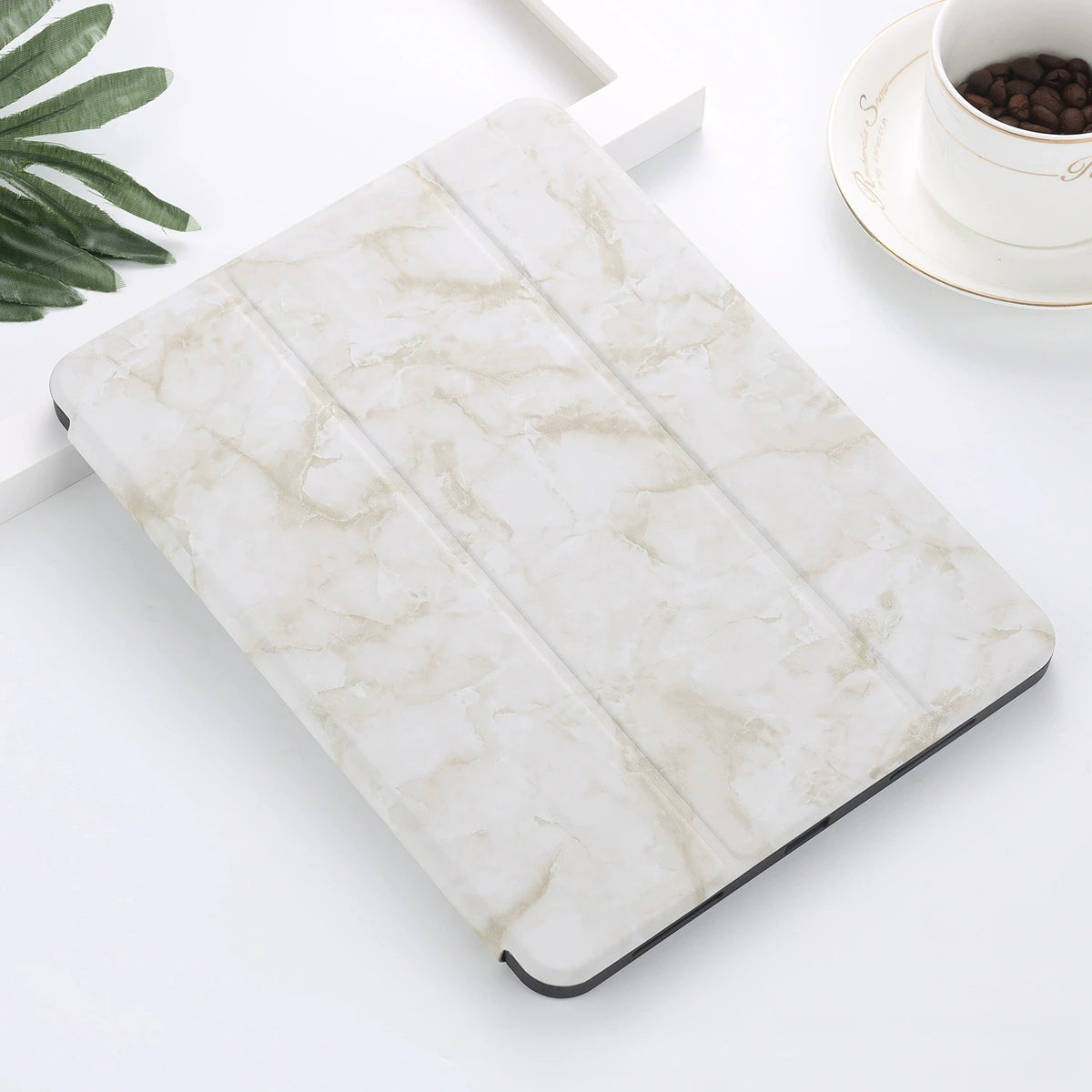 A white marble-patterned silicone skin for an iPad Pro placed on a white surface.