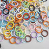 A collection of colorful spring clasps and rings in various colors like pink, yellow, orange, green, and white.