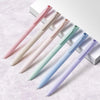 A pack of six pastel gel pens in various shades of pink, green, and blue laid diagonally on a white surface.