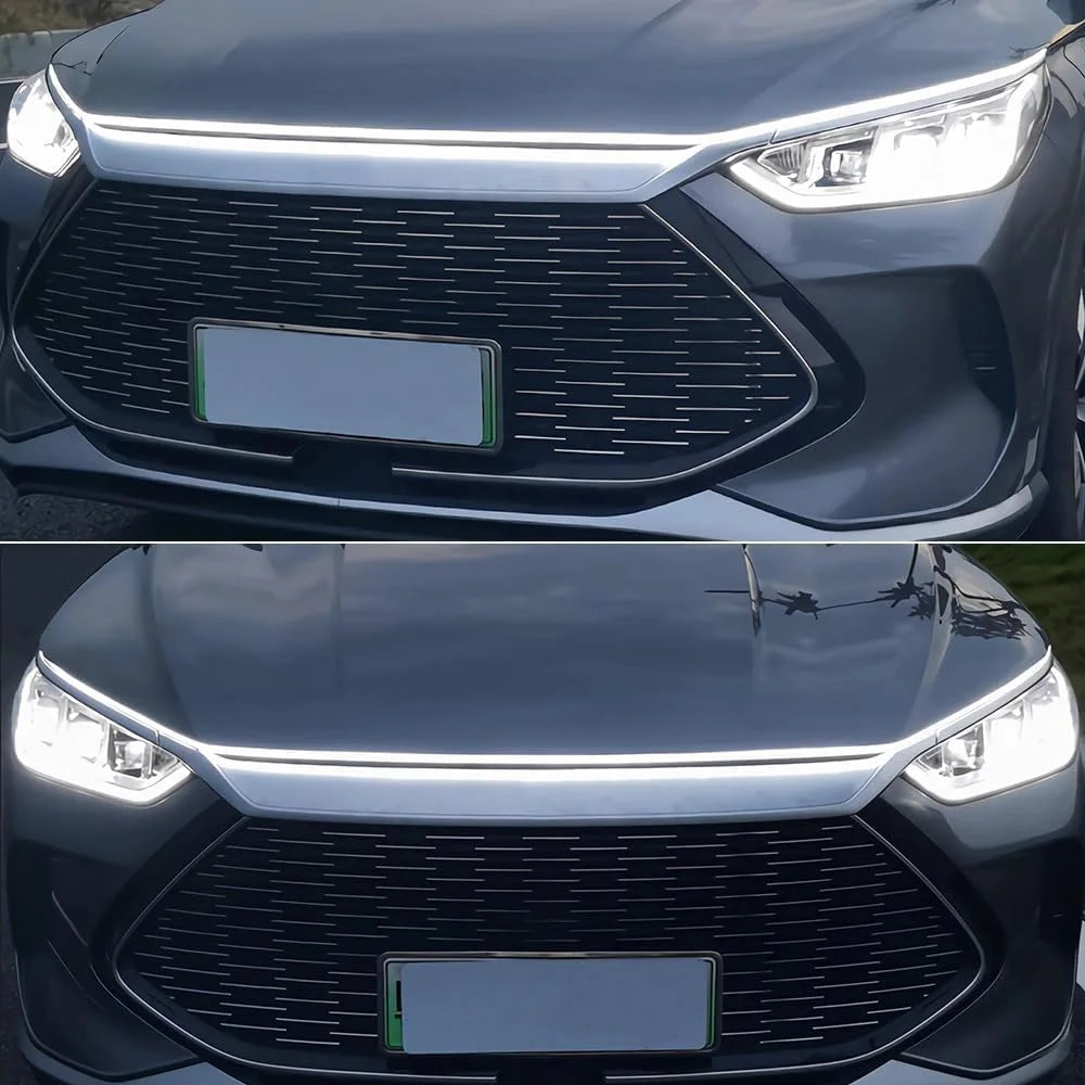 Nahaufnahme der Frontgrill und Motorhaube eines Autos mit integriertem LED-Streifen.